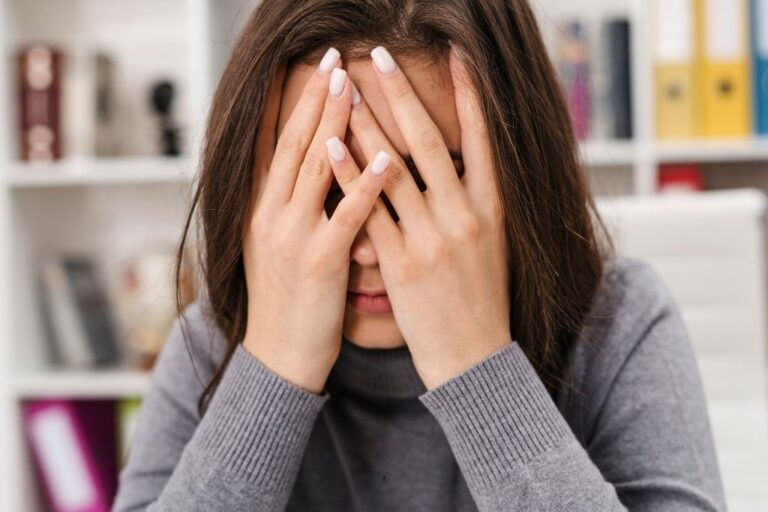 Bloqueo emocional: mujer con las manos en la cara, agobiada y sin poder expresar lo que siente