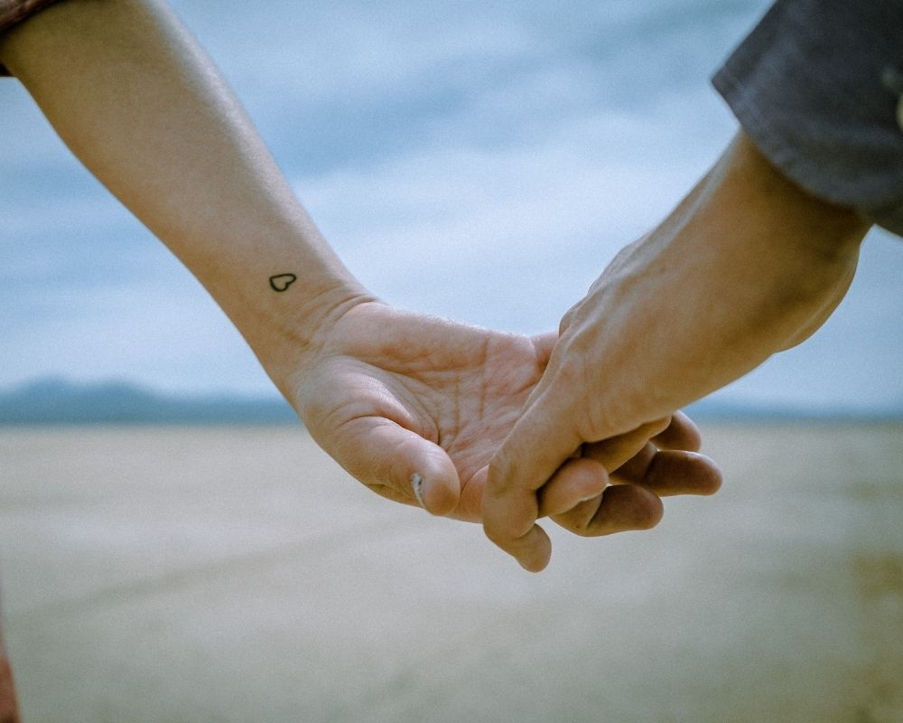 Pareja agarrada de la mano superando una crisis de pareja